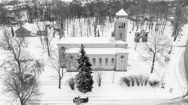 Akniste, Jekabpils, Letonia, Bálticos. Hermosa vista aérea panorámica de avión no tripulado volador a la Iglesia Católica Akniste En nieve blanca en un día de invierno nevado. Patrimonio arquitectónico. (serie) - Foto, imagen