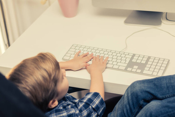 家庭でデスクトップPCを使用している間の小さな子供の電子学習.  - 写真・画像