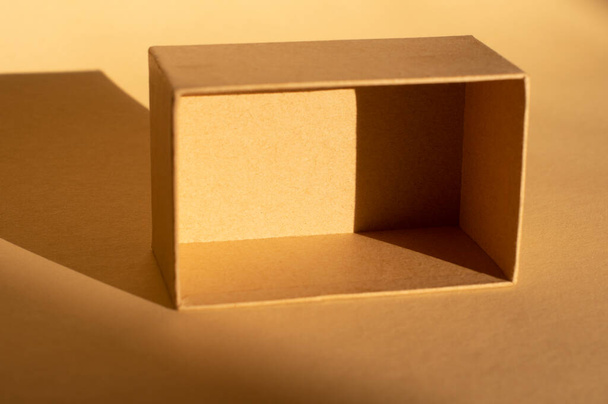 brown cardboard box on beige background and its shadow . Packaging - Fotó, kép