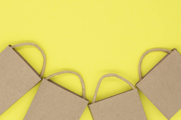 paquetes de artesanía sobre un fondo amarillo. idea creativa para compras en línea, venta, supermercado, promoción de descuento y concepto de viernes negro. Copiar espacio para texto - Foto, Imagen