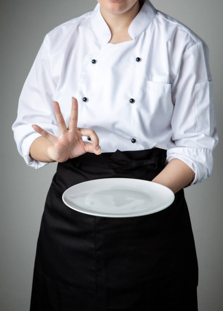 séf egyenruha fehér üres tányérral üdvözöljük ajándék étel étterem promóció - Fotó, kép