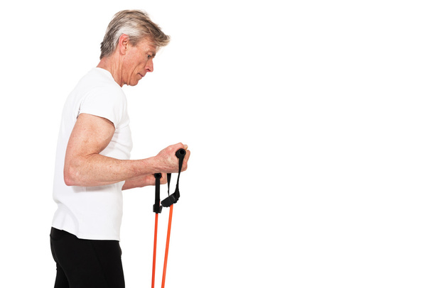 Старший фітнесмен тренується з помаранчевою еластичністю. Ізольовано на
  - Фото, зображення
