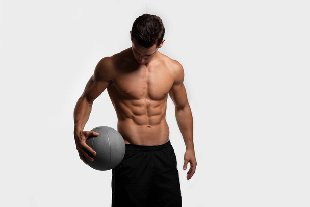 Guapo joven fitness deportivo fuerte hombre desnudo pecho deportista muscular jugador de baloncesto aislado sobre fondo blanco. - Foto, imagen