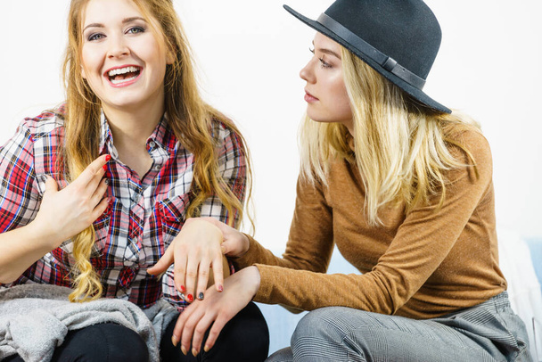 Two fashionable female friends having fun time together showing their beautiful painted nails. - Foto, afbeelding