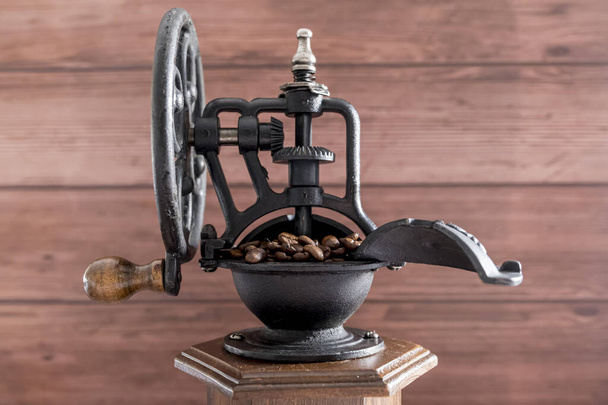 Старинная ручная кофемолка с кофейными зернами  - Фото, изображение