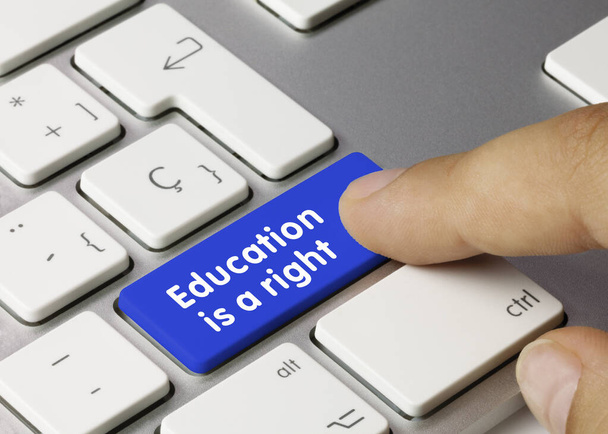La educación es un derecho escrito en la tecla azul del teclado metálico. Pulsando la tecla. - Foto, imagen