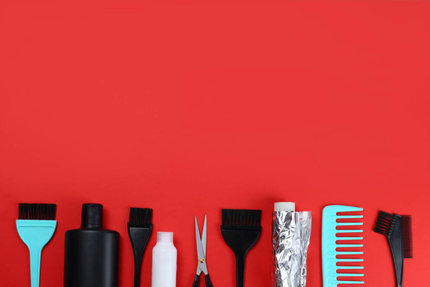 Herramientas para tinte, para el cuidado del cabello para la peluquería, topview sobre fondo rojo. Espacio para texto - Foto, imagen