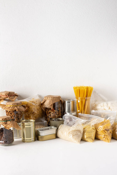 Home food supplies, necessary food for the period of quarantine and isolation, the concept of stay at home, canned food and cereals, various pasta and flour, sugar with honey and coffee - Photo, Image