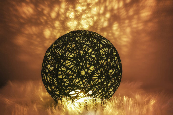 Una esfera brillante hecha de una red similar a un tejido en un ambiente atmosférico - Foto, Imagen