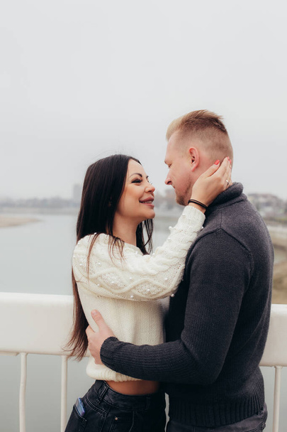 Young woman gently hugs her man against the background of a foggy river landscape - Foto, imagen