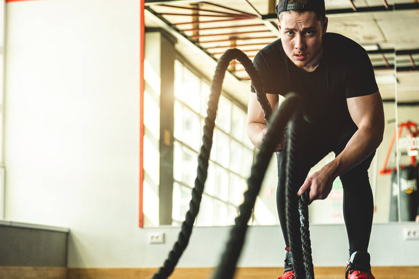 Exercise in the gym with ropes. The athlete is training. - Fotoğraf, Görsel