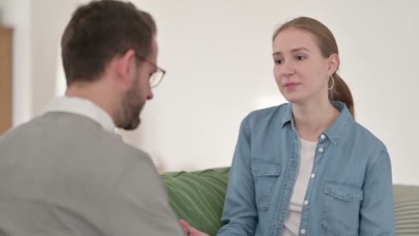 Femme heureuse ayant une conversation avec l'homme sur le canapé  - Séquence, vidéo