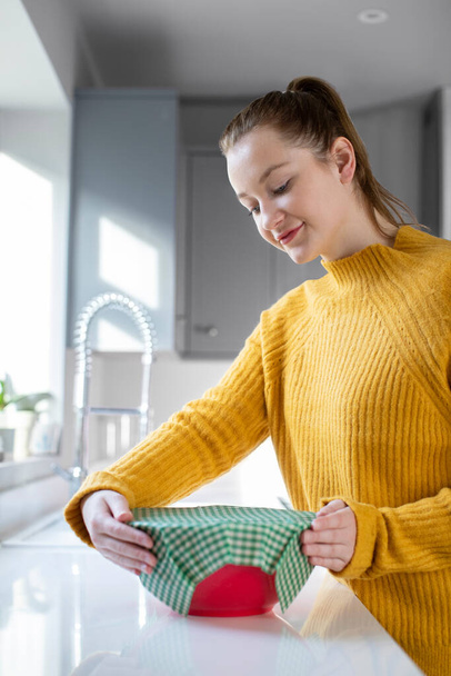 Woman Wrapping Food Bowl In Reusable Environmentally Friendly Beeswax Wrap - Foto, afbeelding