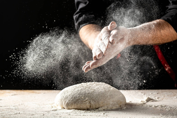 Photo of flour and men hands with flour splash. Cooking bread. Kneading the Dough. Isolated on dark background. Empty space for text. - Photo, Image