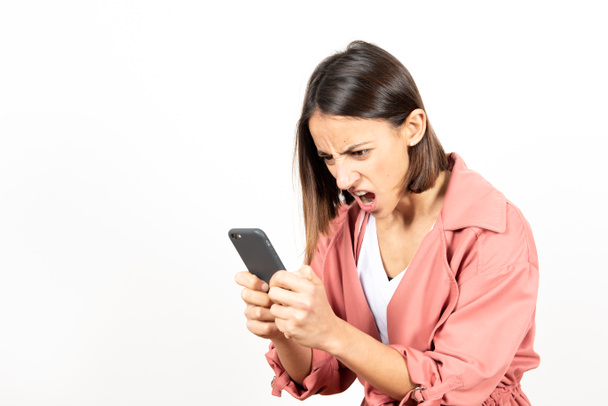 Mujer latina enojada mirando su teléfono celular. - Foto, imagen