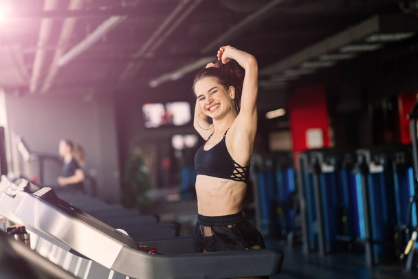 Mladá žena cvičení fitness a cvičení při běhu na trati ve sportovním klubu - Fotografie, Obrázek