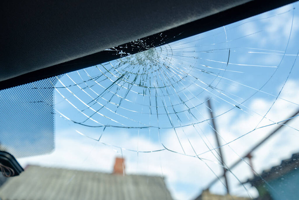 Frontscheibe zerbrochen mit vielen Rissen und kleinen Glasstücken, beschädigtes Auto - Foto, Bild