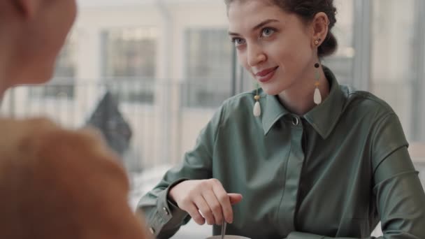 Rückansicht der jungen lockigen schönen kaukasischen Frau, die am Cafétisch sitzt und ein Date mit einem unkenntlichen Mann vor sich hat - Filmmaterial, Video