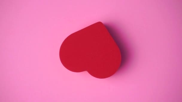 Il cuore rosso sullo sfondo rosa. San Valentino, amore, romanticismo, concetto di matrimonio. Arte minimale video creativo con il cuore - Filmati, video
