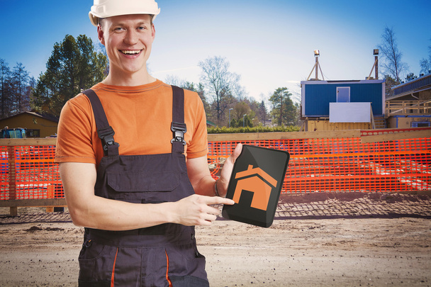 Trabajador de la construcción mostrando plan de tableta
 - Foto, imagen