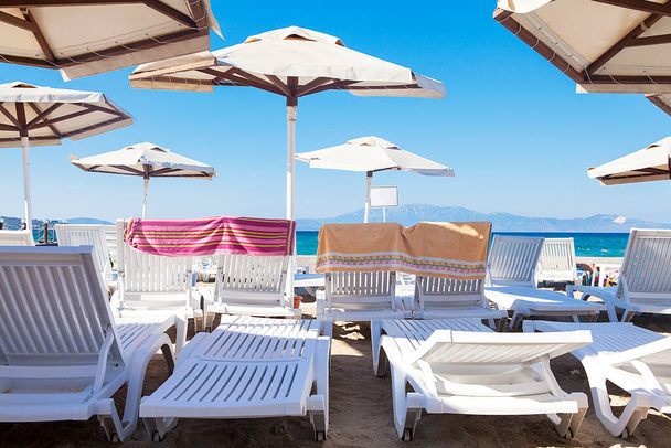 Sombrillas y sillas en un día soleado y a orillas del mar.  - Foto, Imagen