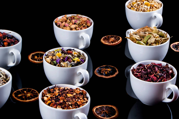 Vários tipos de ingredientes de chá de ervas em copos sobre fundo branco. Ervas naturais medicina. - Foto, Imagem