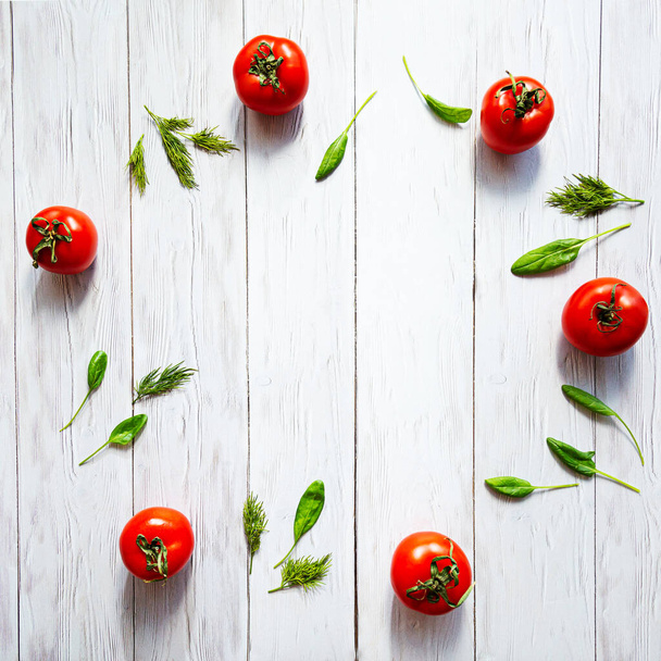 Tomaten, Avocados, Gurken, ganze und halbe, Spinatblätter und Dill liegen flach auf einer weißen Holzoberfläche. Gesundes Essen. Hintergrund der Nahrungsmittel. - Foto, Bild