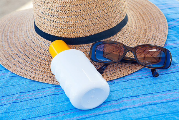 солнцезащитный крем, соломенная шляпа и очки. Концепция расслабления. - Фото, изображение