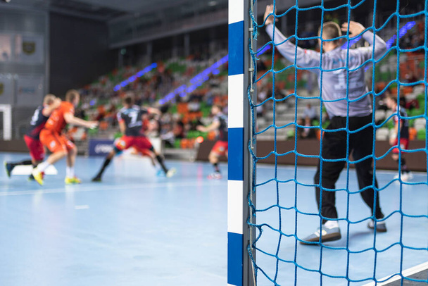 Detail des Handballtorpfostens mit Netz und Handballspiel im Hintergrund. - Foto, Bild