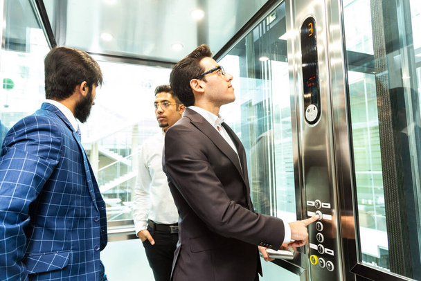 Business team group going on elevator. Business people in a large glass elevator in a modern office. Corporate businessteam and manager in a meeting. - Foto, Imagem