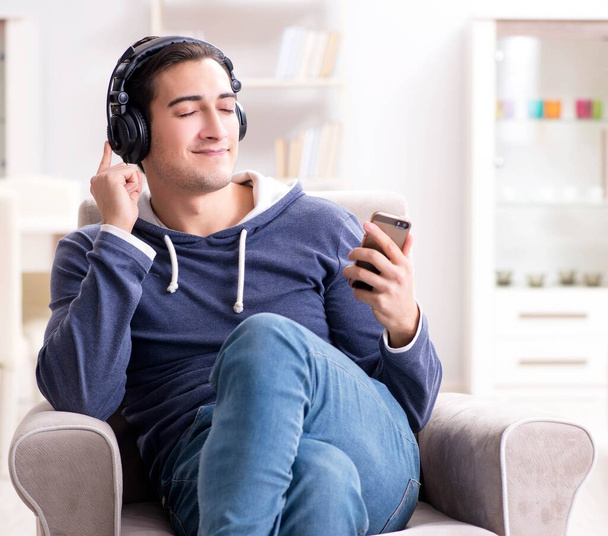 Fiatal jóképű férfi zenét hallgat fejhallgatóval - Fotó, kép