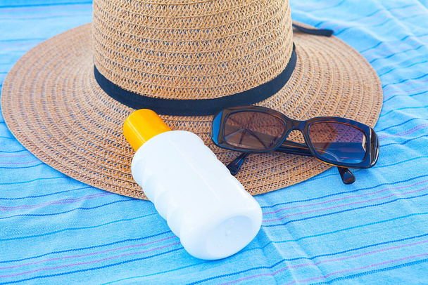Sunscreen, straw hat and glasses. The concept of relaxation. - Photo, Image