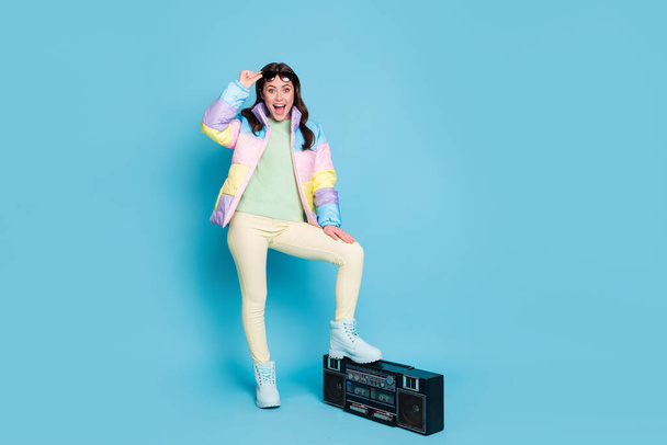 Photo portrait full body view of amazed screaming woman lifting up glasses with foot on boombox isolated on pastel blue colored background - Фото, изображение