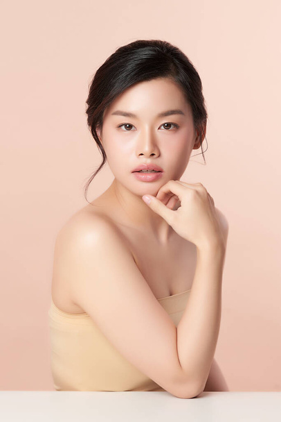 Schöne junge asiatische Frau mit sauberer, frischer Haut auf beigem Hintergrund, Gesichtspflege, Gesichtsbehandlung, Kosmetologie, Schönheit und Wellness, Asiatisches Frauenporträt - Foto, Bild