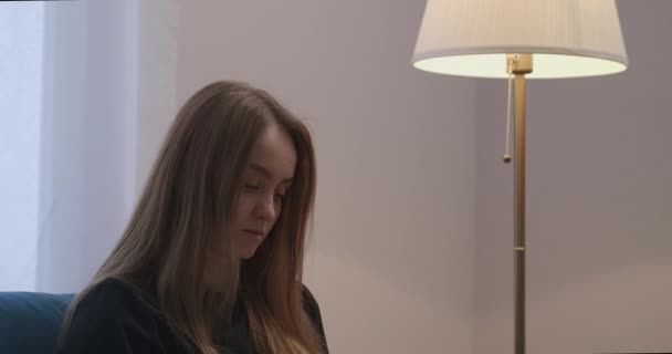 hübsche Frau mit langen Haaren ruht im Wohnzimmer der Wohnung und schaltet das Licht der Stehlampe aus - Filmmaterial, Video