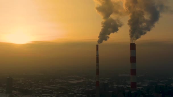 Emissioni delle centrali elettriche viste sopra la città durante l'alba. Inquinamento ambientale. Tubo di fabbrica inquinamento atmosferico.Panorama tramonto. pipe fumatori Vista aerea, - Filmati, video