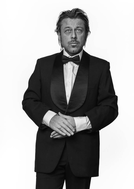 Man in tuxedo in front of white background. Black and white photo. - Photo, Image