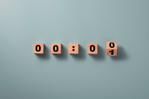 Bloque de cubo de madera volteando para cambiar el número uno a cero en el fondo azul para el concepto de cuenta atrás. - Foto, imagen