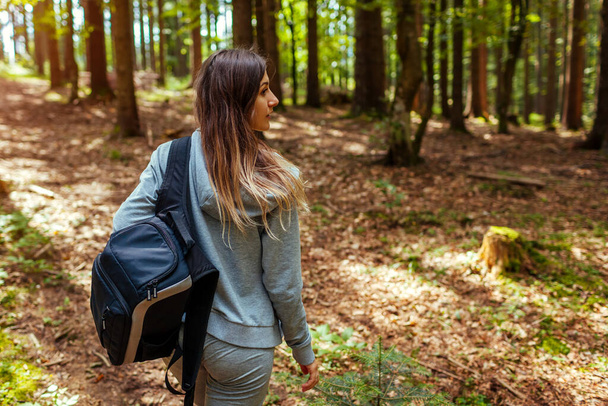 Жіночий турист, який ходить лісом Карпатських гір, насолоджується краєвидом. Подорожі з рюкзаком влітку в Україну. - Фото, зображення