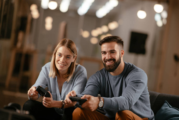 Coworkers playing video games in office. Couple having fun. - Photo, Image