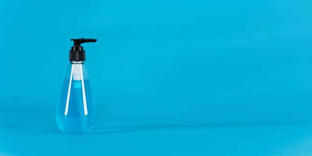 Mavi arka planda bakteri ve virüs önleyici alkol jeli temizleyiciler - Fotoğraf, Görsel