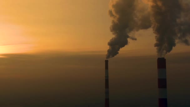 Kraftwerksabgase bei Sonnenaufgang über der Stadt. Umweltverschmutzung. Fabrik-Rohr verschmutzt Luft. Panorama Sonnenuntergang. Pfeifen rauchen Luftaufnahme, - Filmmaterial, Video