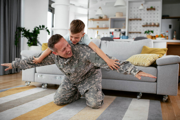katona férfi játszik a fiával otthon  - Fotó, kép