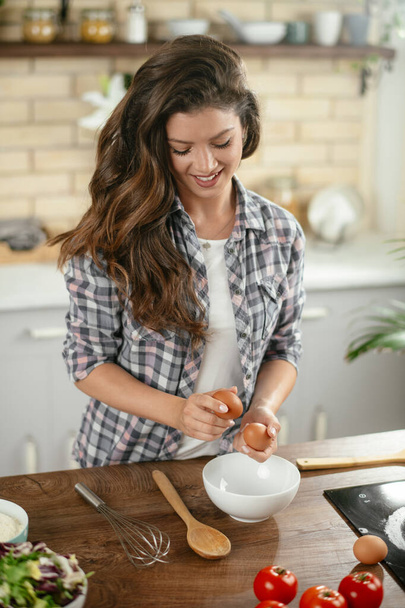 Retrato de una hermosa joven cocinando en la cocina. Mujer joven cocinando. Comida saludable - Ensalada de verduras. - Foto, Imagen
