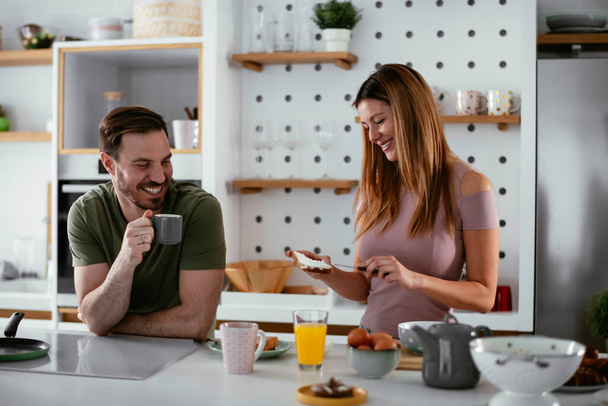 ευτυχισμένο ζευγάρι τρώει πρωινό στην κουζίνα  - Φωτογραφία, εικόνα