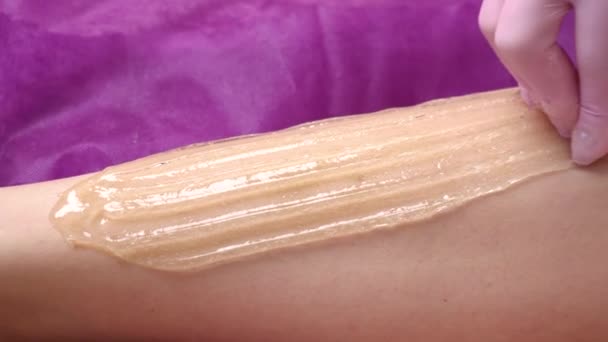 Schoonheidsspecialiste waxen vrouwenbeen in schoonheidssalon. Procedure voor benen huiveren. - Video