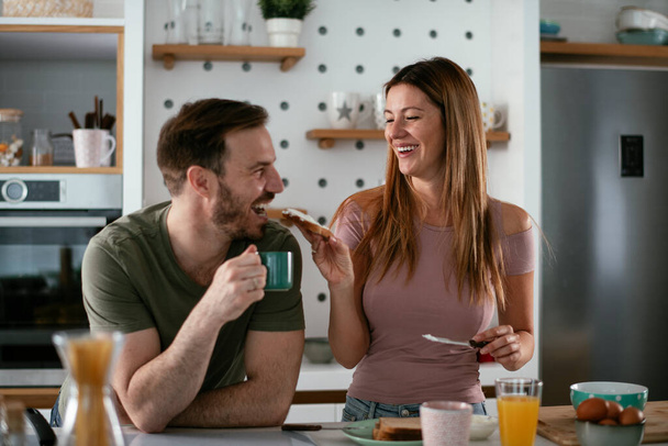 boldog pár együtt reggelizik a konyhában  - Fotó, kép