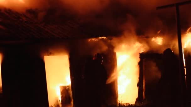 木造の建物の火災では、消防士がドアに侵入します。救助活動. - 映像、動画