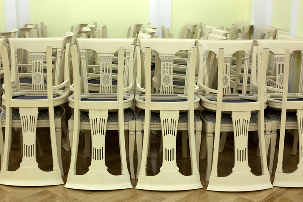 белые стулья, сложенные в деталях. - Фото, изображение