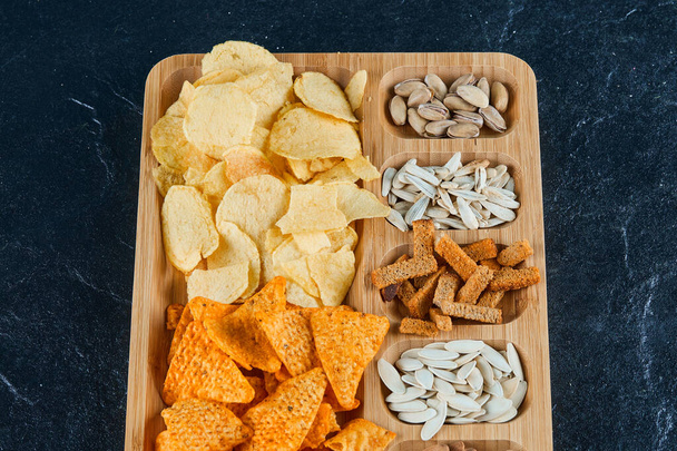 Plate of assorted snacks on a dark background - Photo, Image